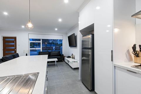 Open kitchen and living area with a stone island and windows to the street