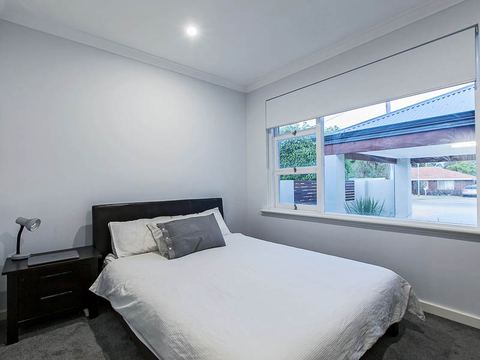Bedroom with a wide window looking onto the front garden