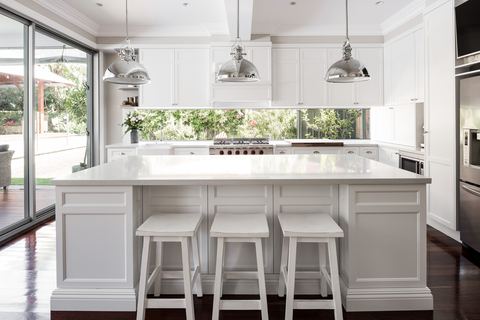 Kitchen with a shaker-profile island, polished steel pendants and a window splashback