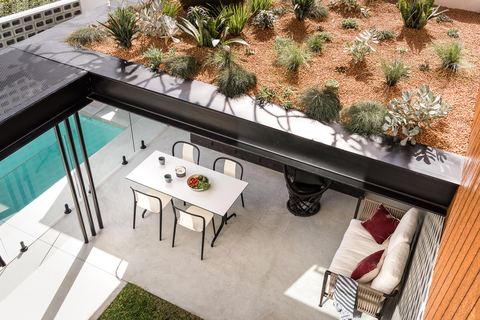 Elevated view over the pool terrace, with a dining setting under the first-floor overhang
