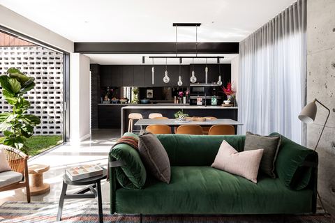 Open-plan kitchen and living room, the breeze-block screen filtering light across the floor