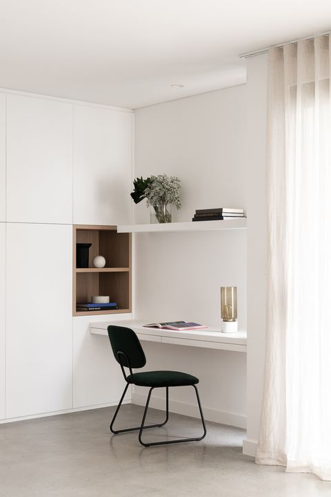 Study nook with built-in white joinery, open timber shelving and a sheer curtain