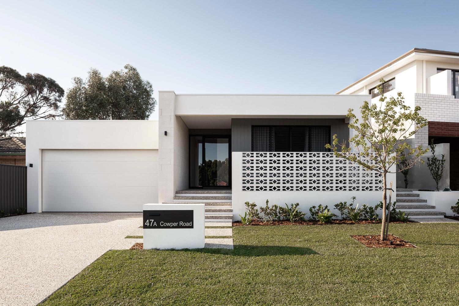 Single-storey street elevation with a rendered wall, breeze-block screen and new lawn