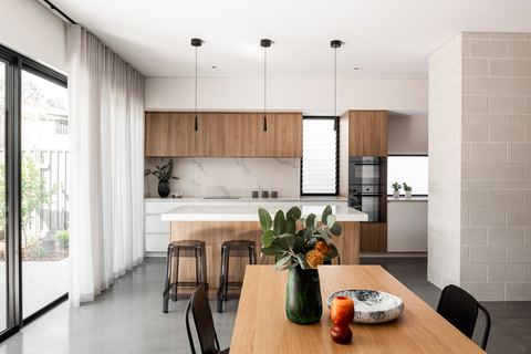 Kitchen with a timber island, stone benchtops and a run of tall cabinetry