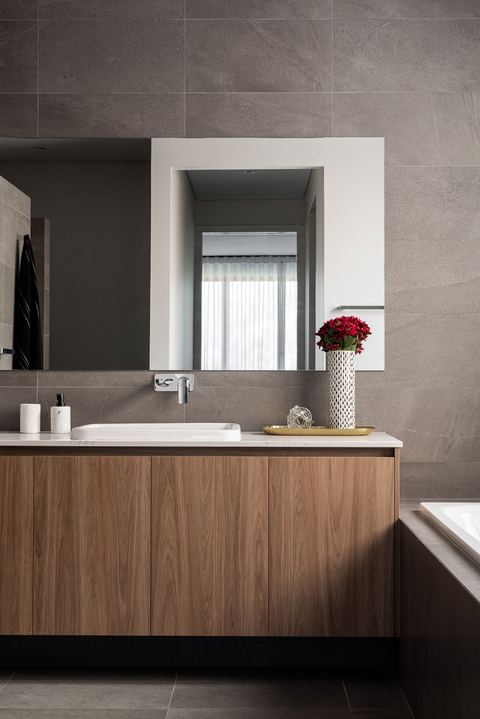 Bathroom with a timber vanity, stone benchtop and a framed mirror