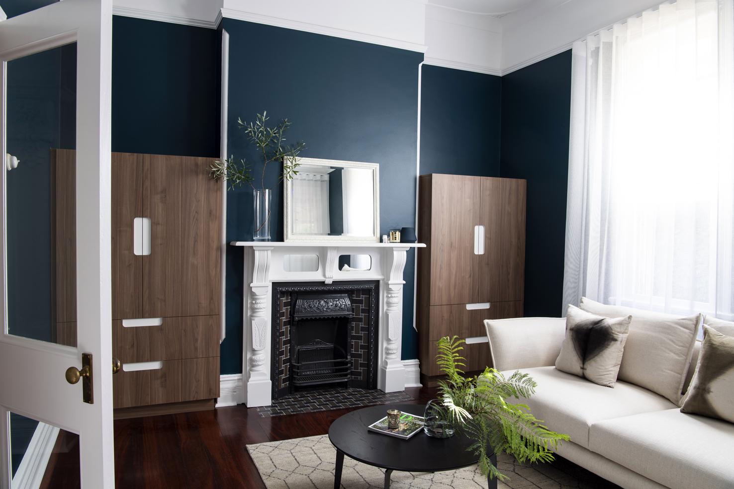 Sitting room with a marble fireplace, deep navy walls and jarrah floors
